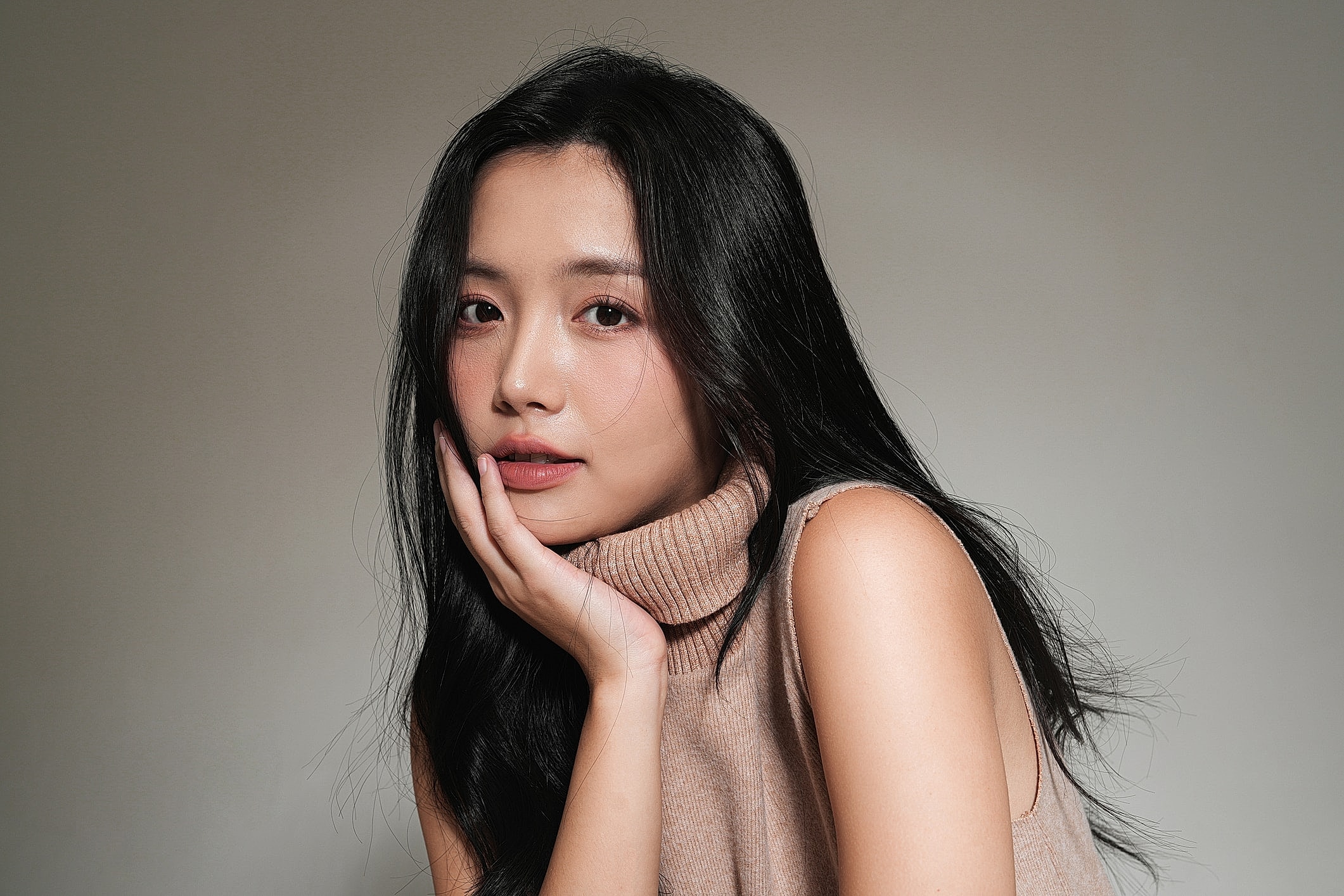 Woman with long hair in turtleneck sweater.